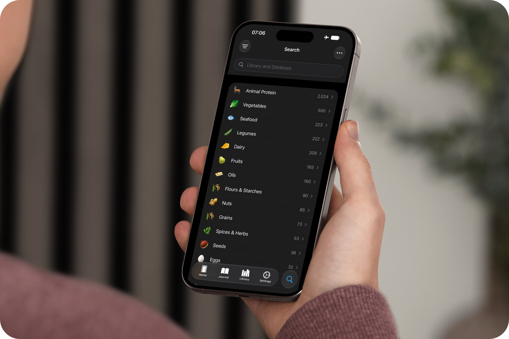 A hand holding an iPhone displaying the whole foods ingredient database